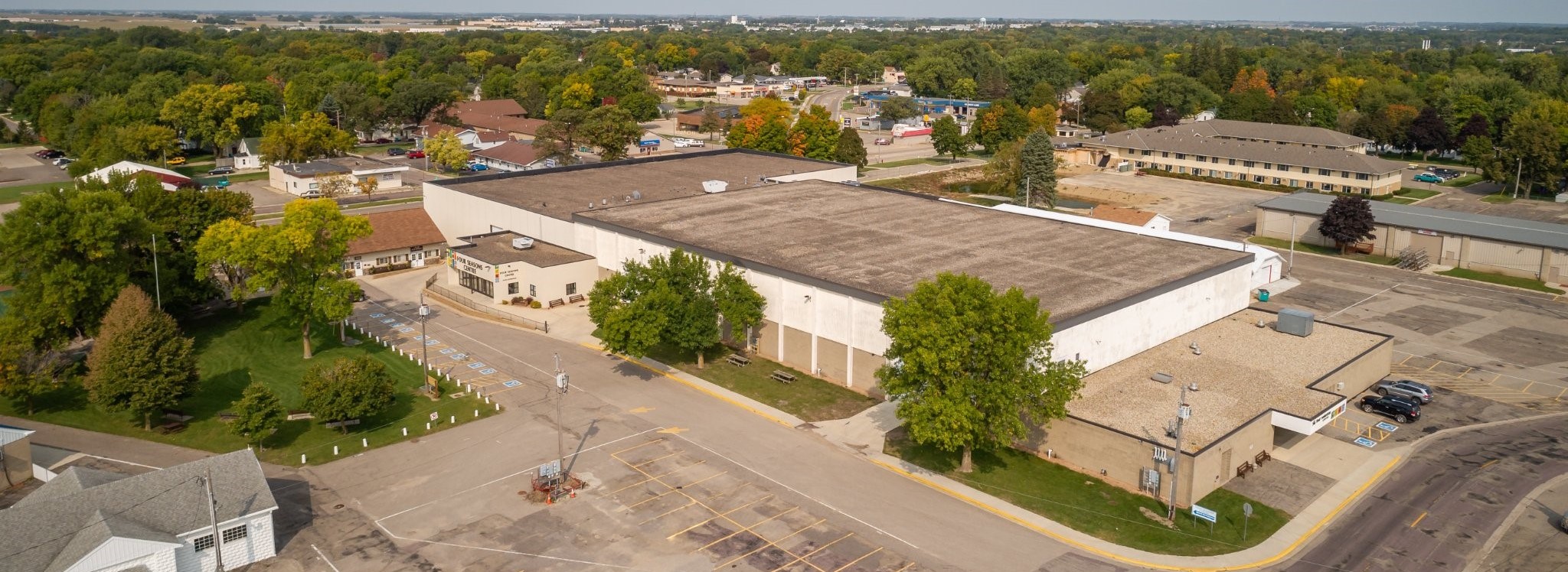 Aerial view of the Four Seasons Centre and surrounding neighborhood, showing the large building, parking lots, trees, and nearby streets.